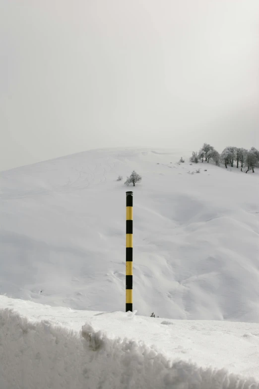 a stop sign sitting on the side of a snow covered hill