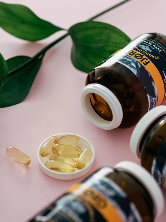 a table topped with a jar of fish oil and two pills