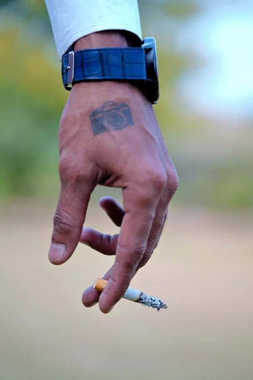 a hand is holding onto a cigarette, with the word no smoking written on it