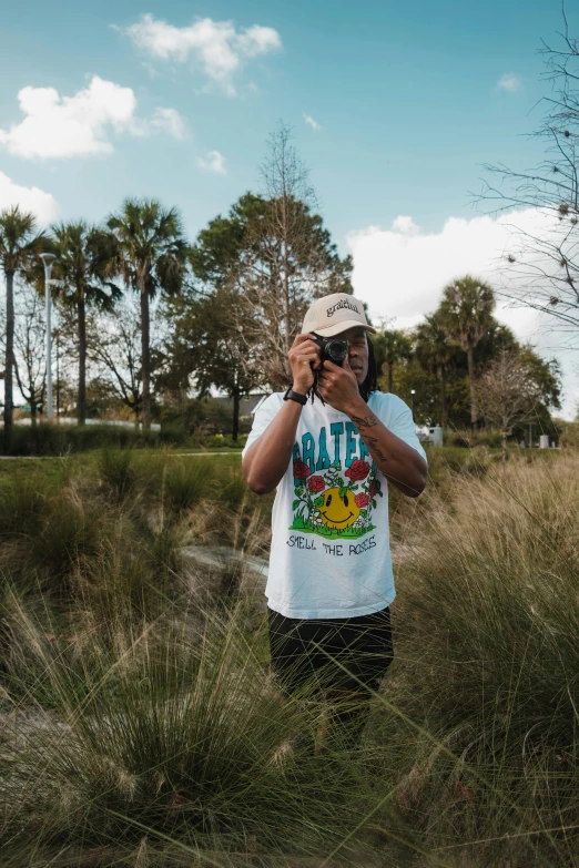 a man holding a camera taking a picture of a field