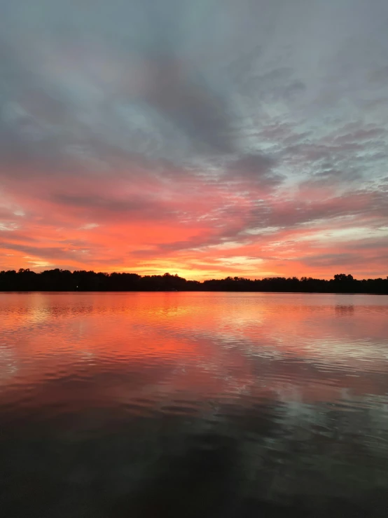 sunset reflects the sky with a few clouds reflected on the water