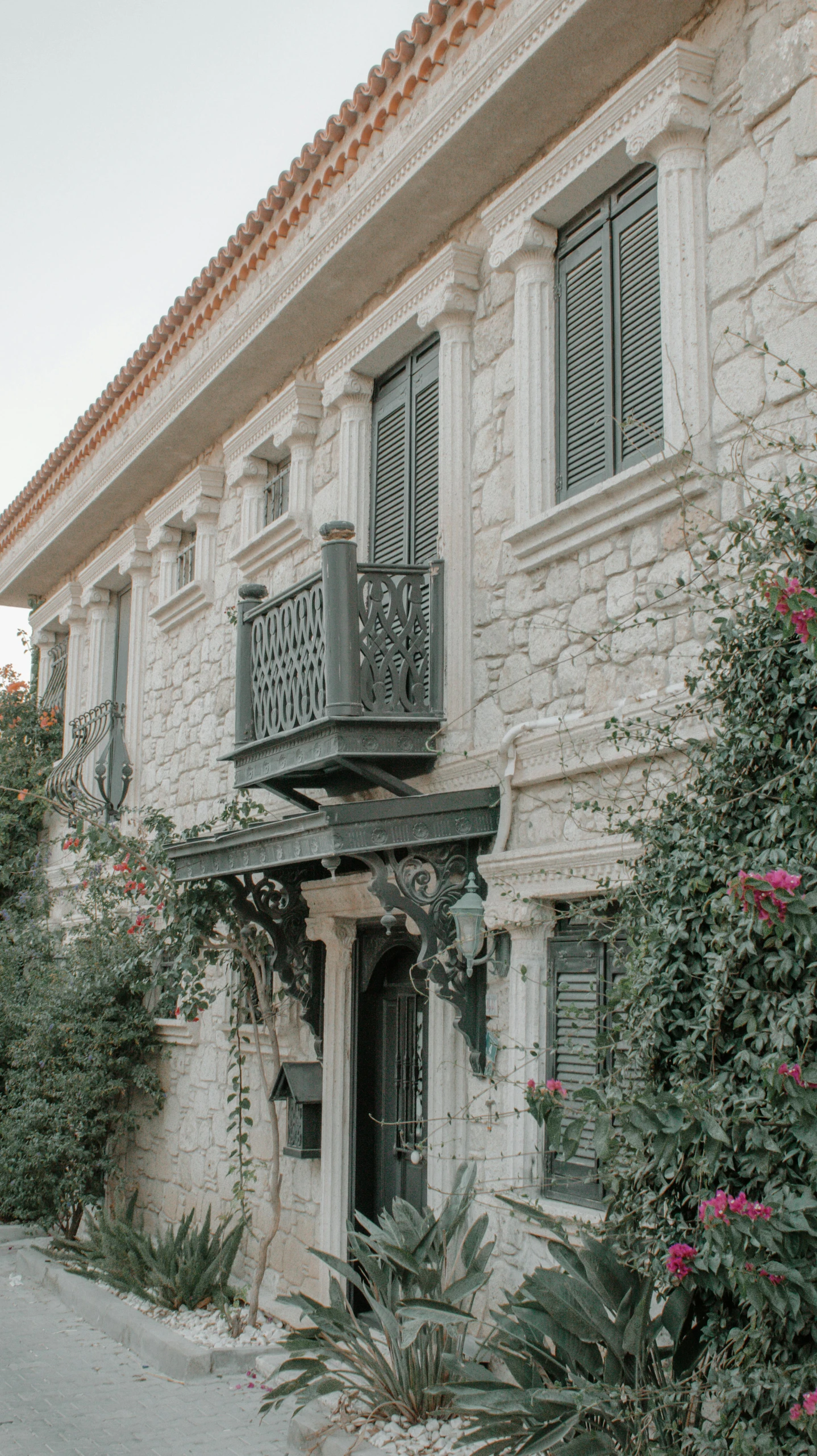 a house with bushes and trees around it