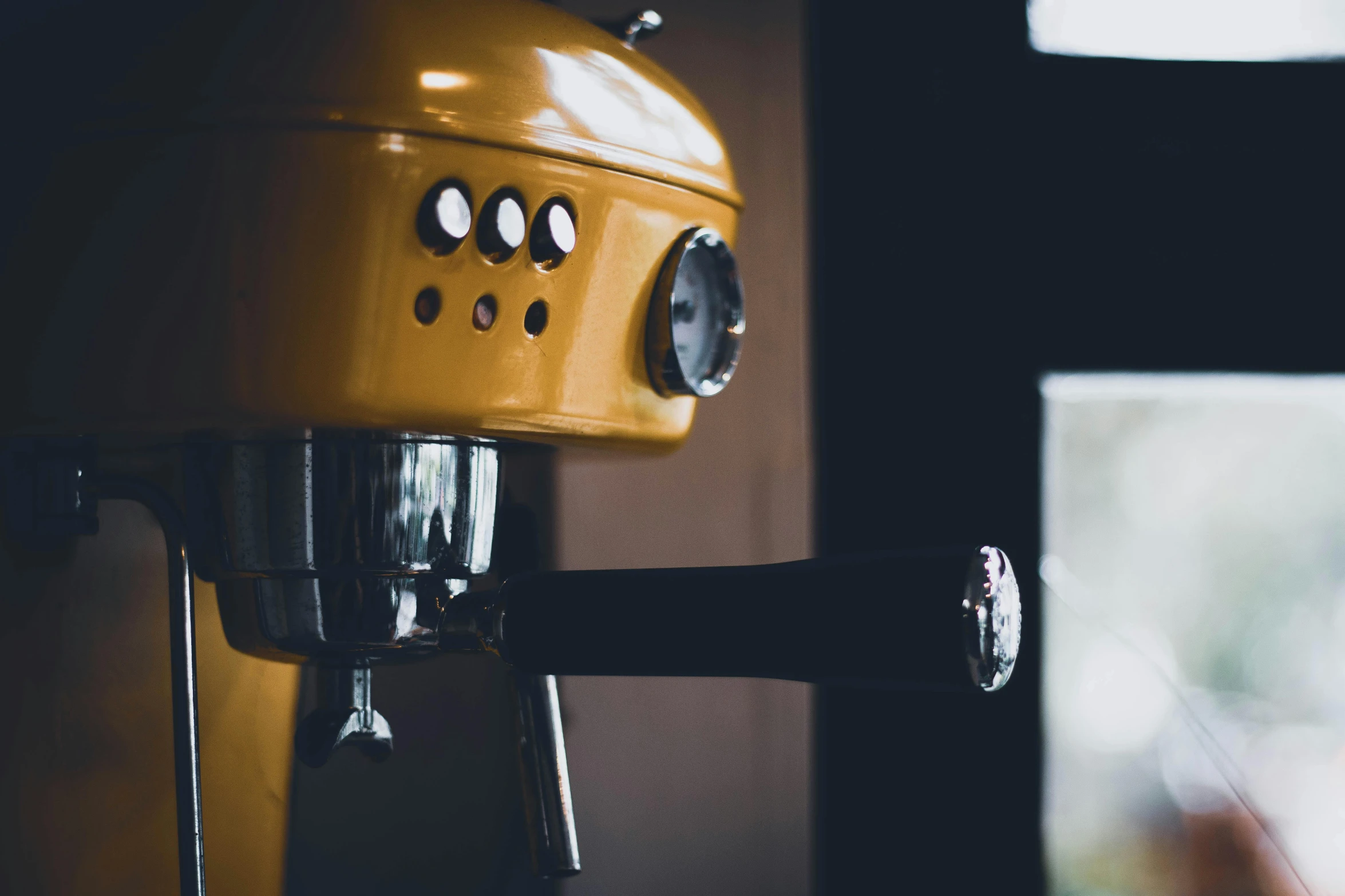 a yellow machine sitting next to a window