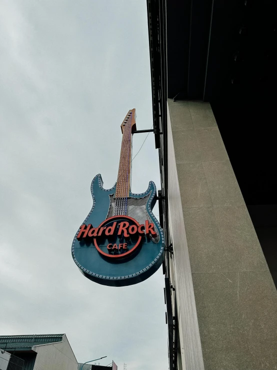 a sign for the rock and roll restaurant hangs off of the side of a building