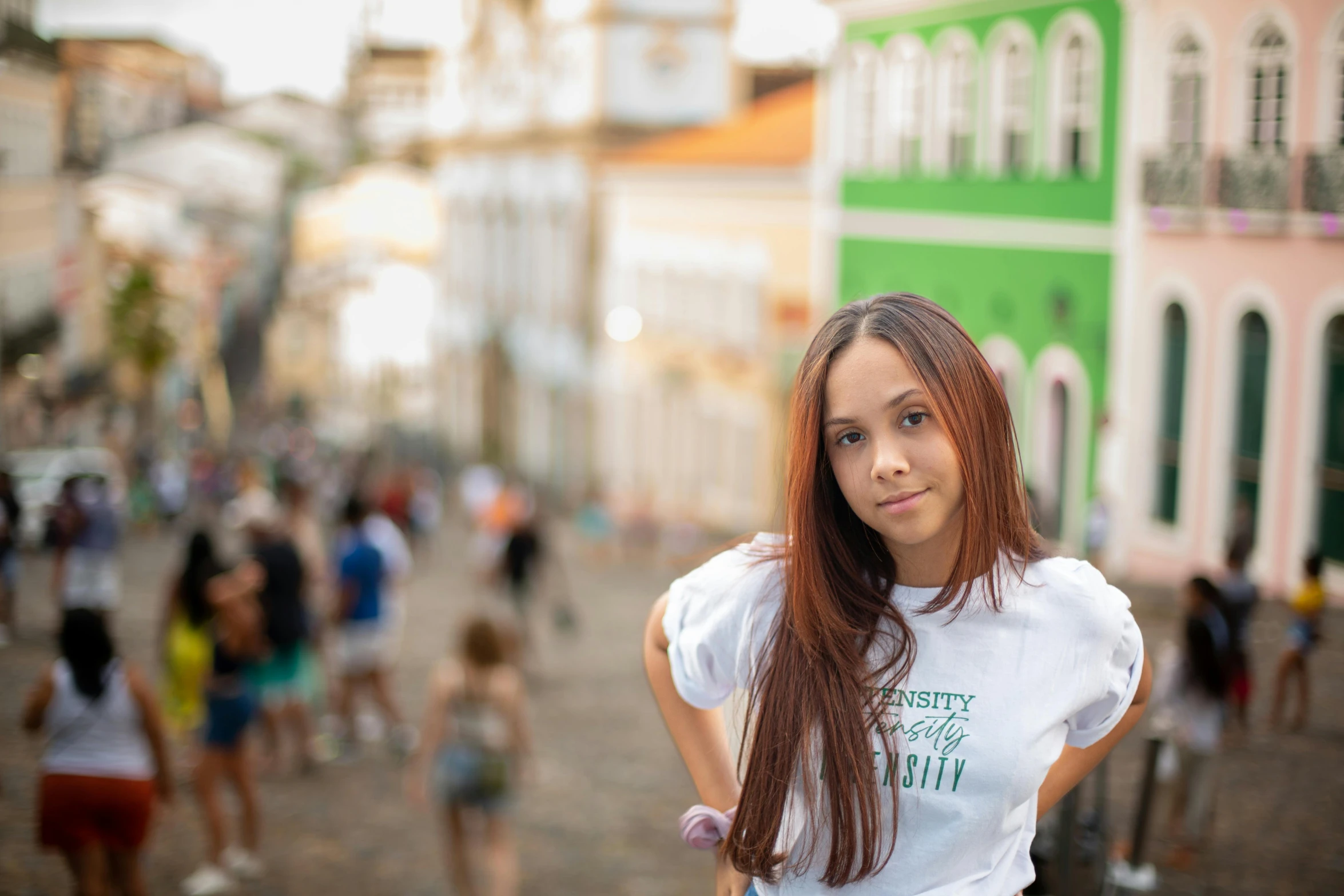 a girl standing in the middle of a street surrounded by people