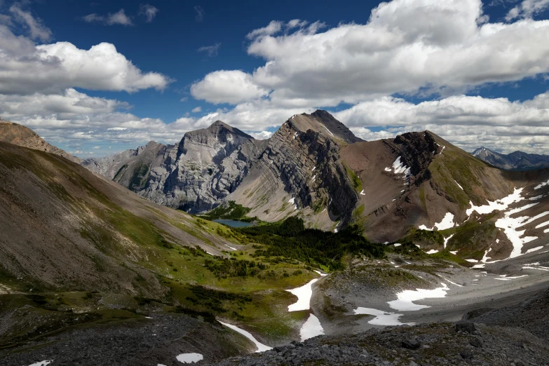 a view of some mountains and grass with sky