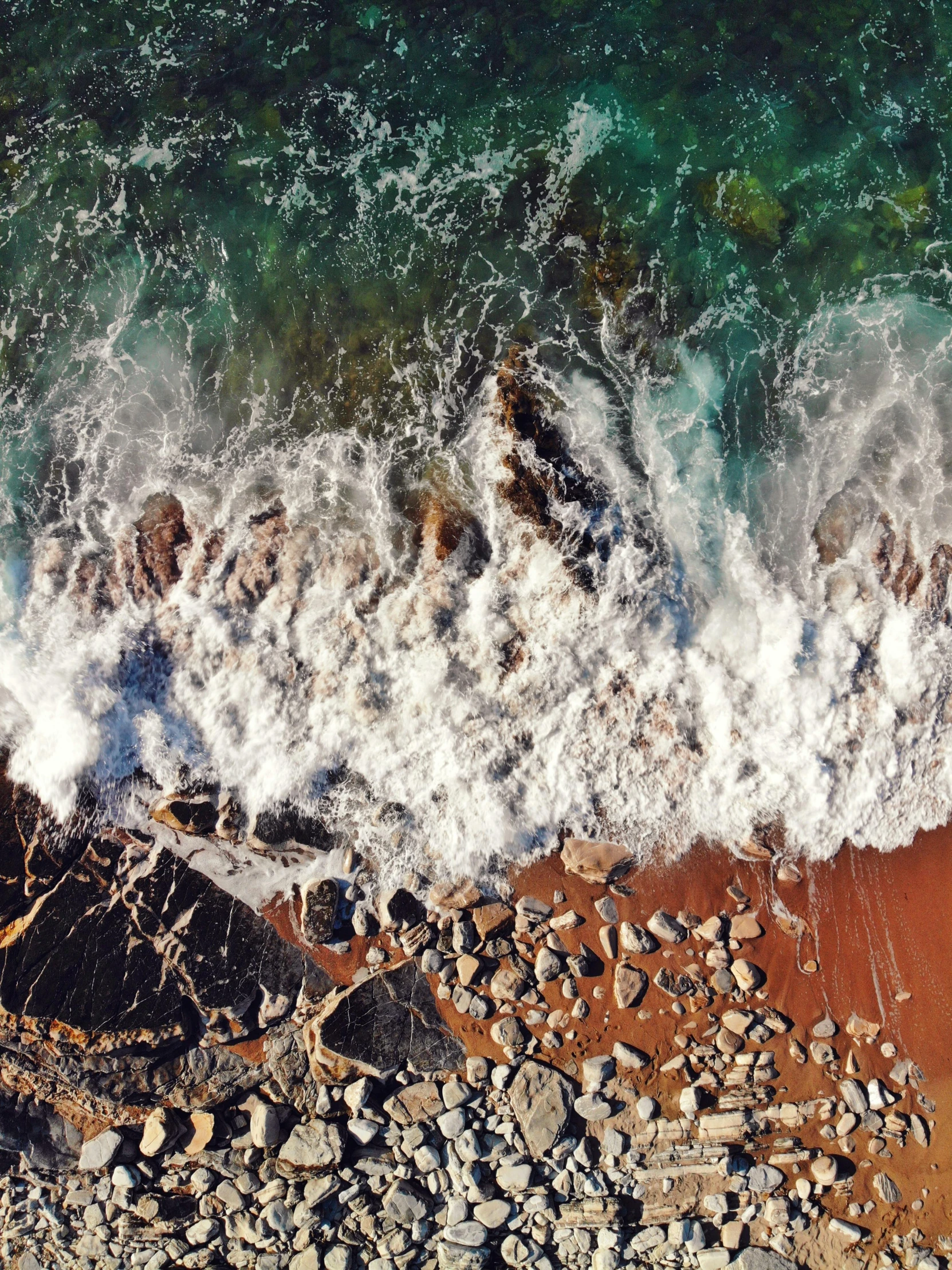 the view from above looking down on an ocean shore and waves