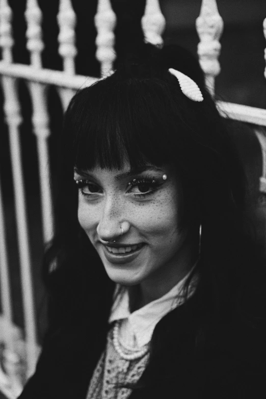 black and white po of young lady wearing earring smiling