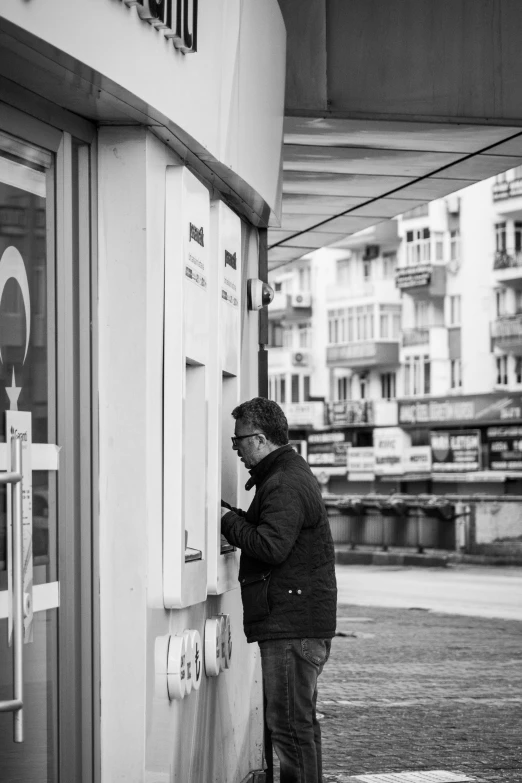 a man standing next to a parking meter and building