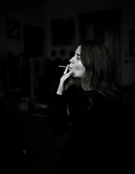 a woman smoking a cigarette in a darkened room