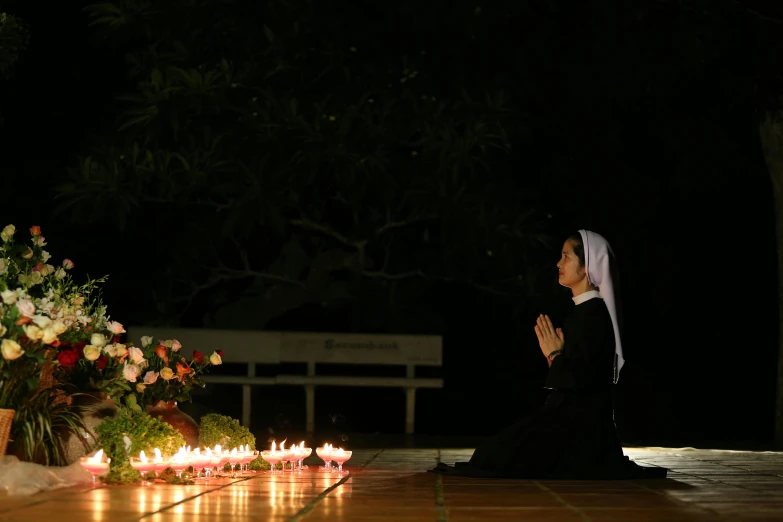 a woman in a dress on a wooden floor with candles