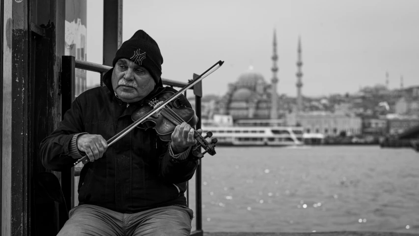 the violinist plays a very old instrument near the water