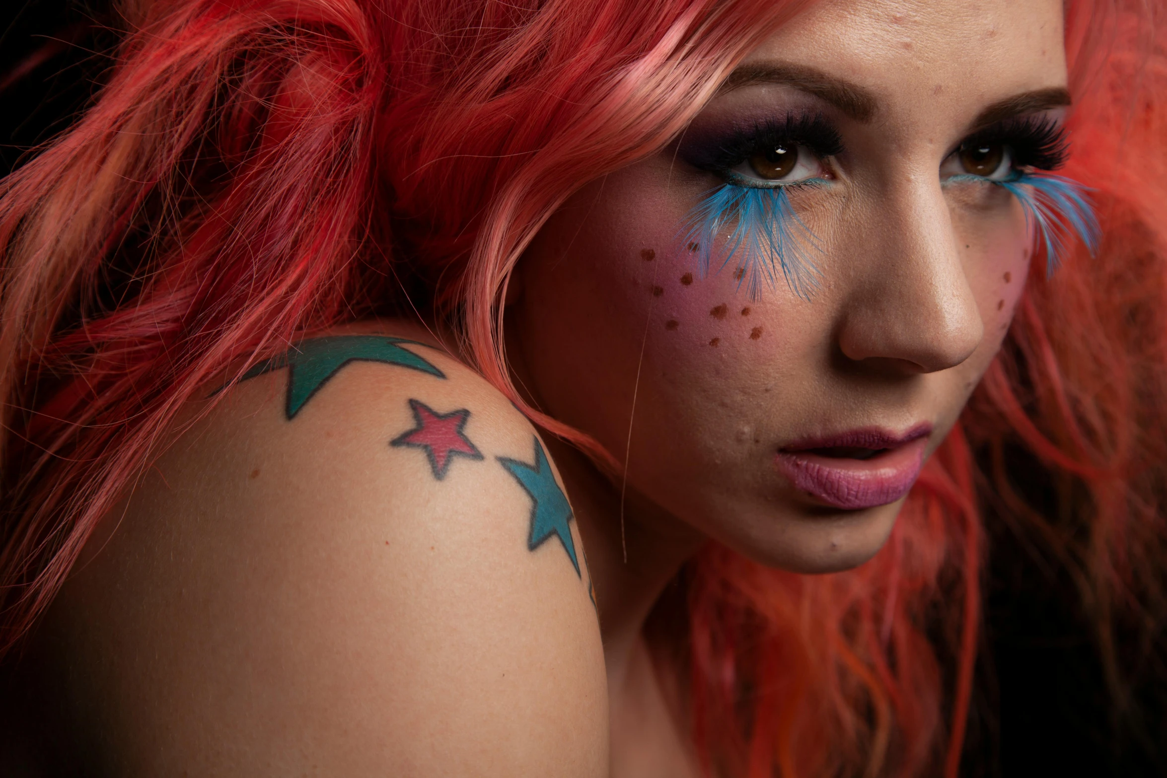 a woman with blue and red makeup on with stars painted all over her body