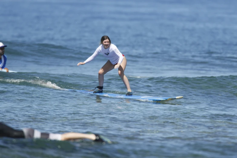 a woman in white is riding on a surfboard