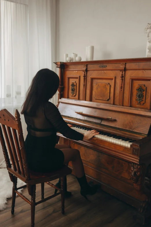 an old woman sitting at a piano in front of a window