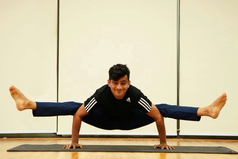 a man who is stretching while on a mat