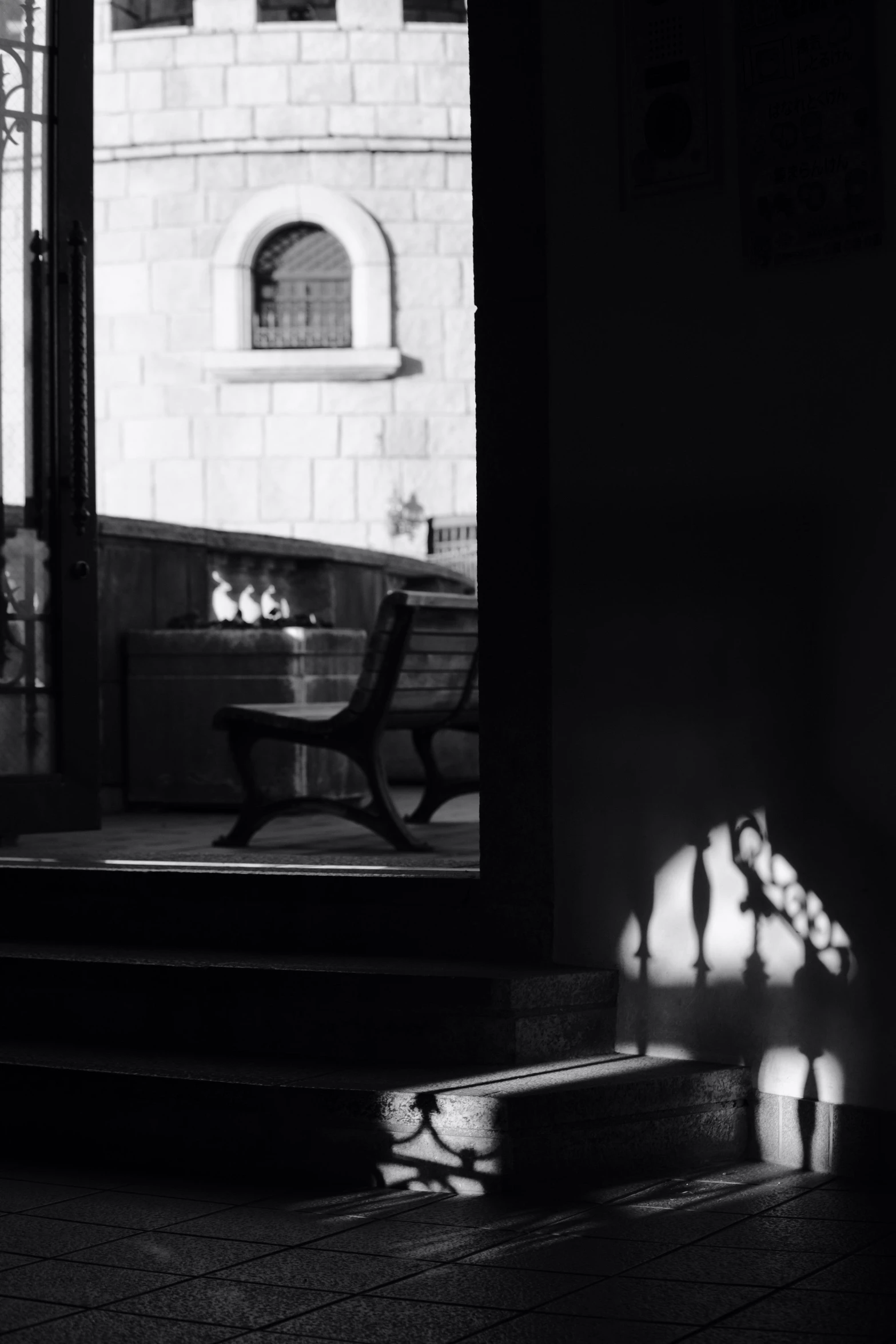 a bench sits in front of a window and some stairs