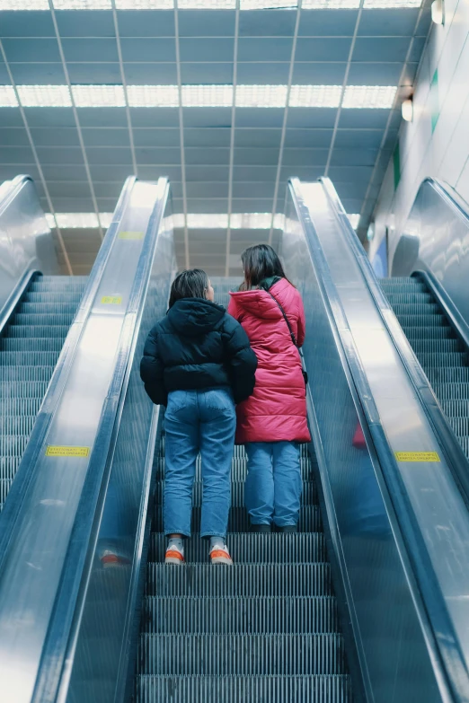 a couple is riding an escalator down the hall