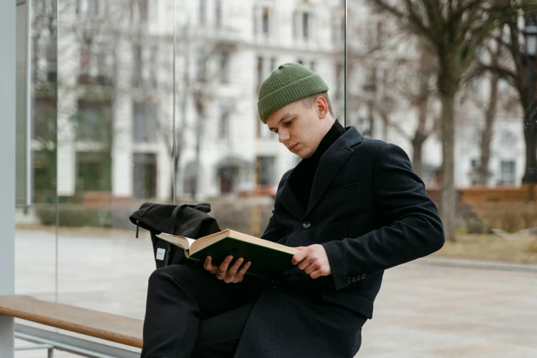 a man sitting down while reading a book