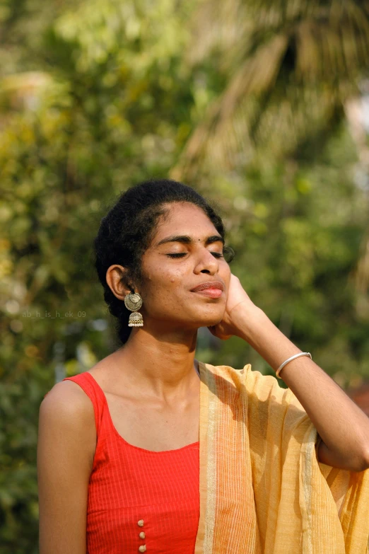 a woman in a red and yellow top looking away from the camera