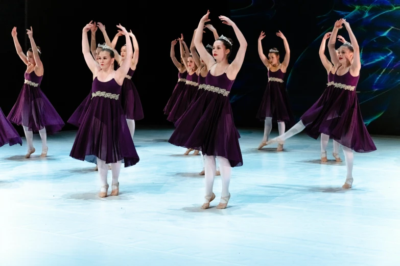 the women in purple are dancing together on the ice