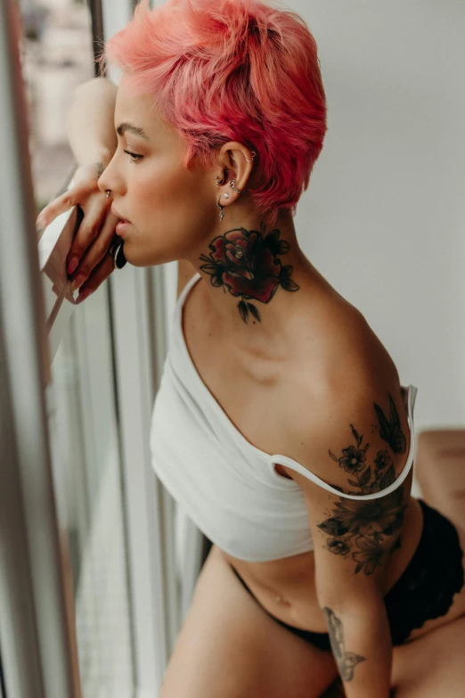 a woman with a tattooed chest, pink hair and a white top