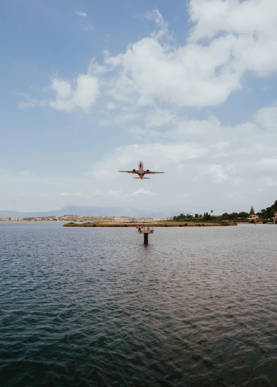 an airplane flies low above the water