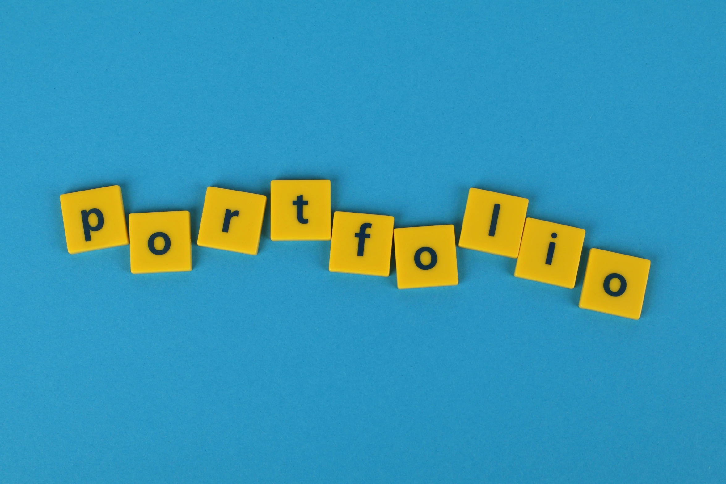 a group of small yellow rubber cubes that spell out portfolio