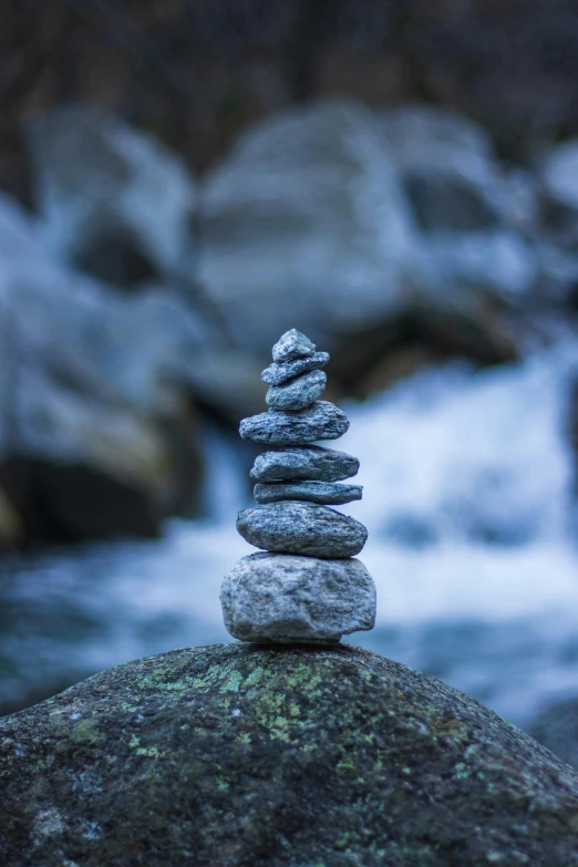 a stack of stones on top of rocks next to water