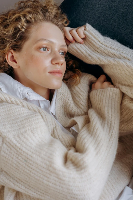 a woman with curly hair wrapped in blanket