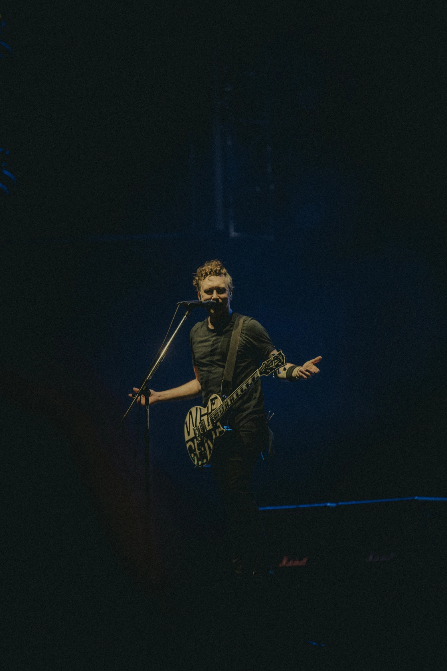 a man singing into a microphone at night