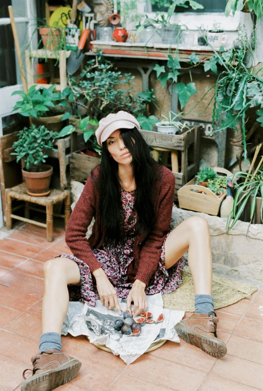 a woman sitting on the ground next to a pile of junk