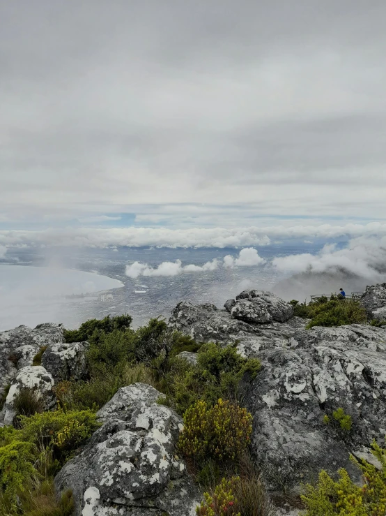 mountains surrounded by clouds with small green vegetation