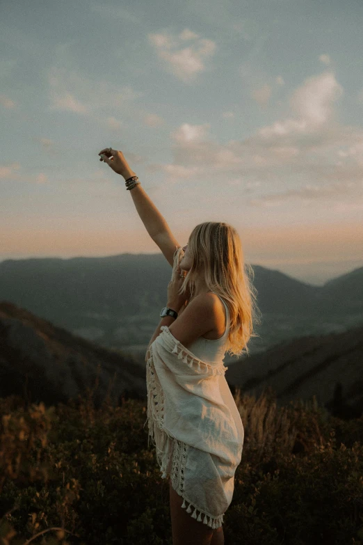 a girl is posing in the mountains on a hike