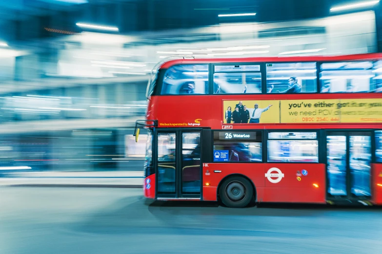 a red double decker bus driving in traffic