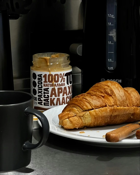 a large loaf of bread next to a mug and a black coffee maker