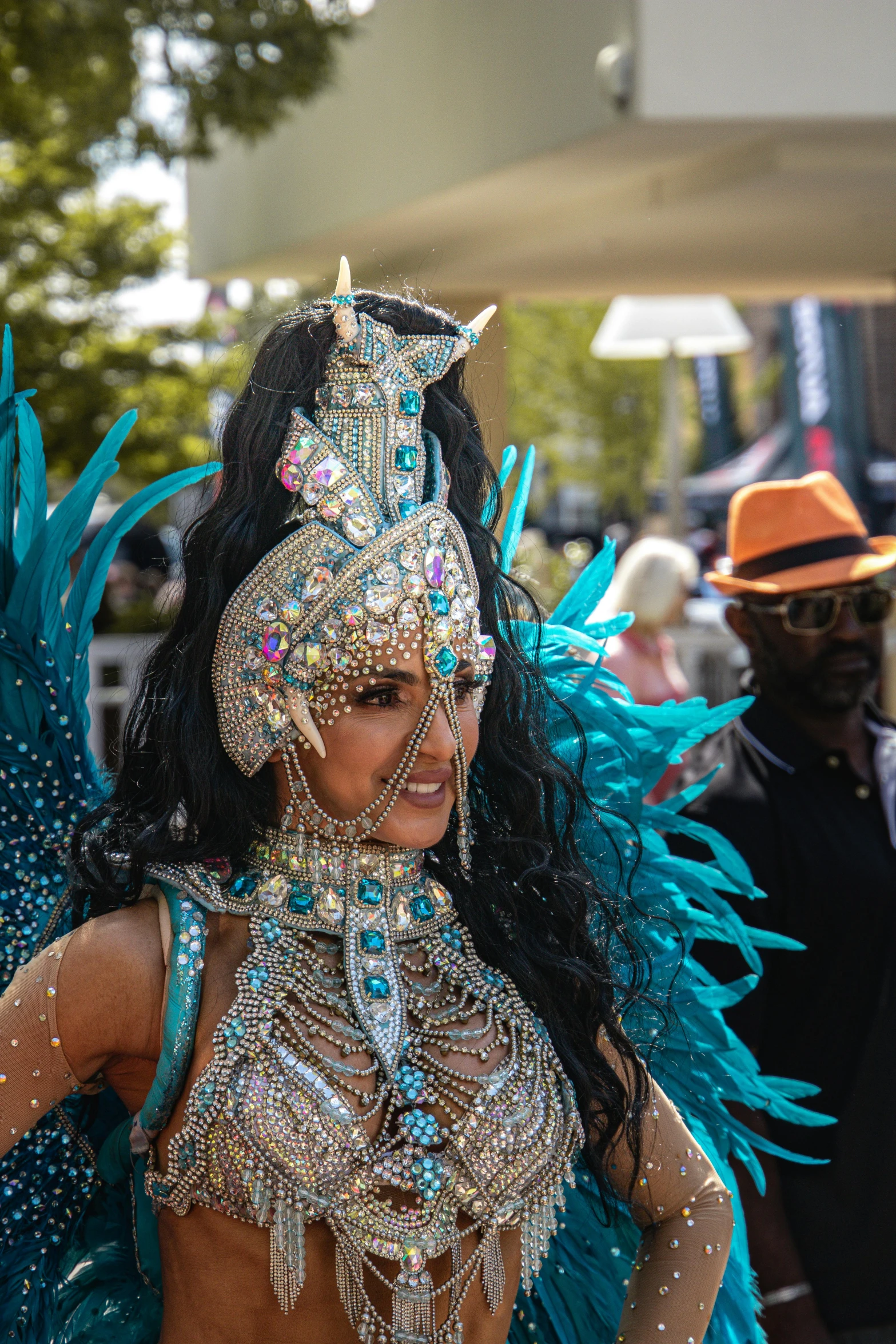 the dancers are in the parade and are all wearing feathers