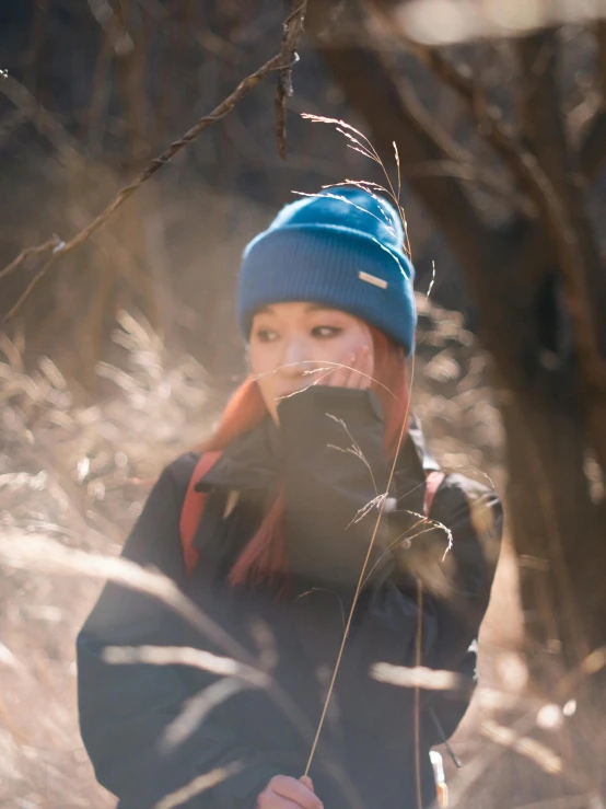 a little girl in the woods with her hat on