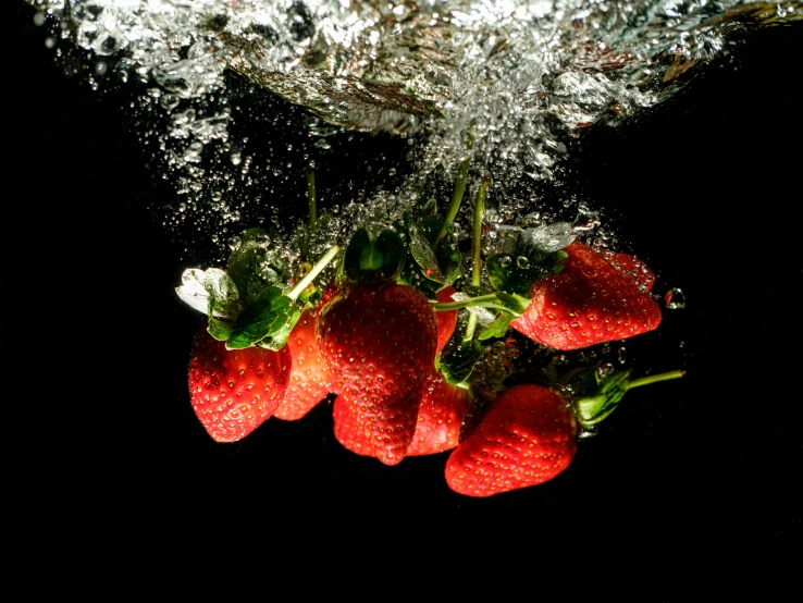 a bunch of strawberries splash in water