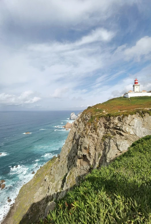 a lighthouse sits on top of a cliff overlooking the ocean