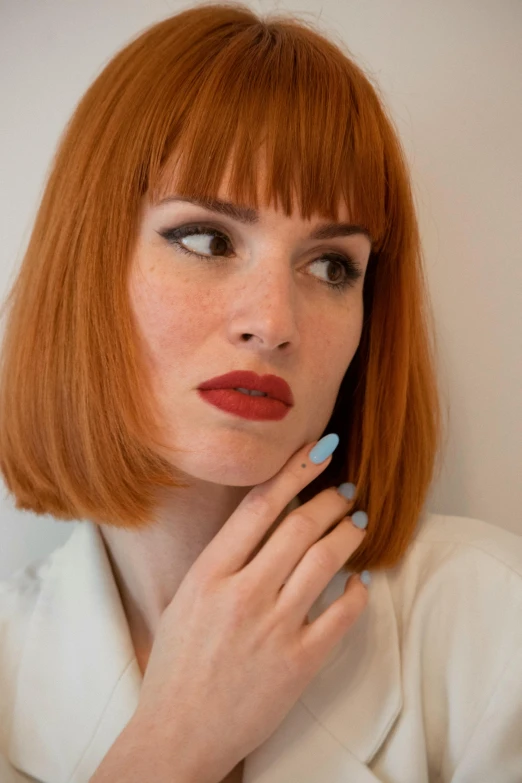 woman with bright blue nails with a short red bobble