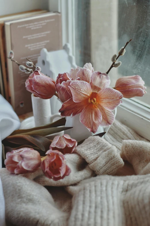 a white cup with some pink flowers inside