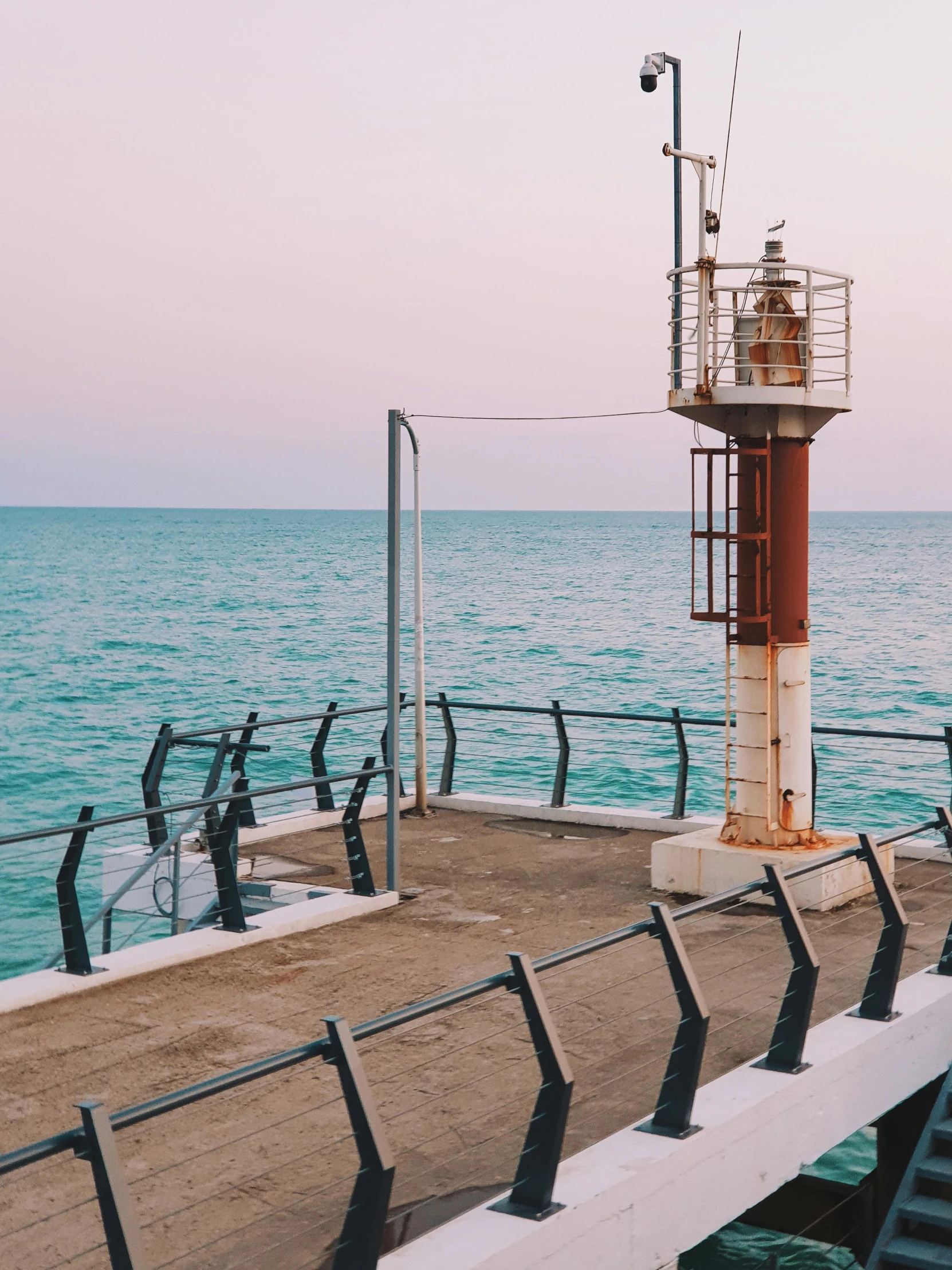 the pier has railings by it to allow people to watch the ocean