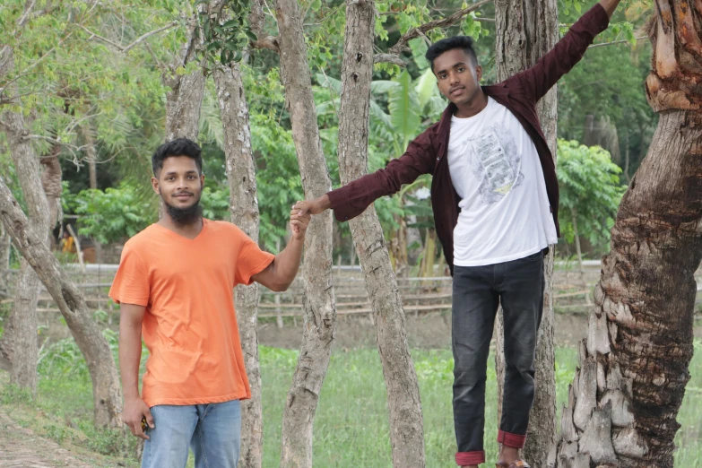 a couple of men standing next to each other near some trees