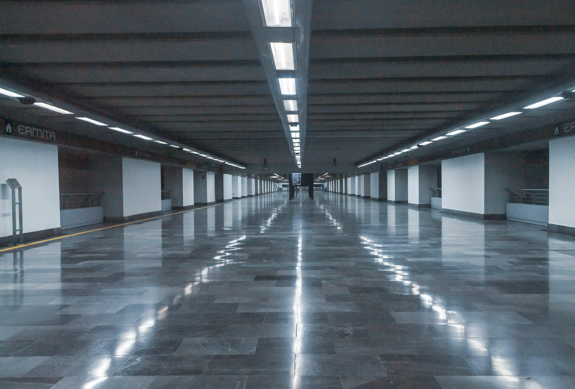 a very long empty subway station with lots of light
