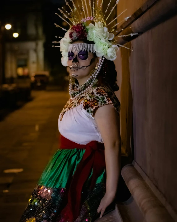 a woman with flowers in her hair standing near a wall