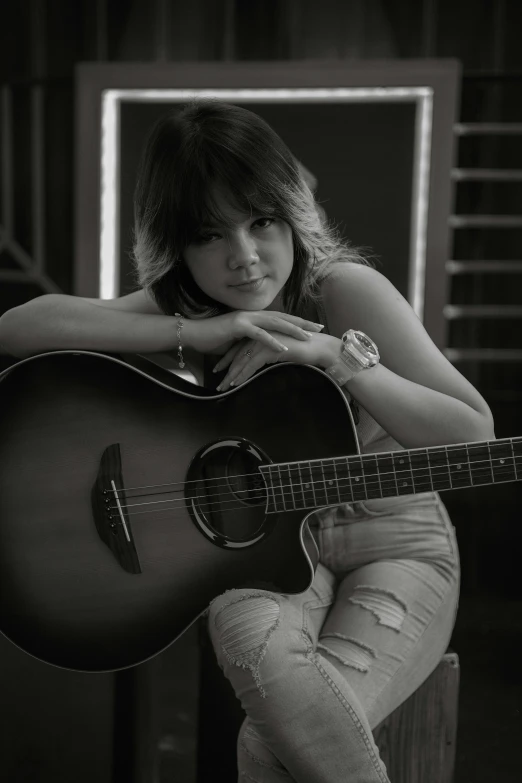 the girl is sitting with her guitar