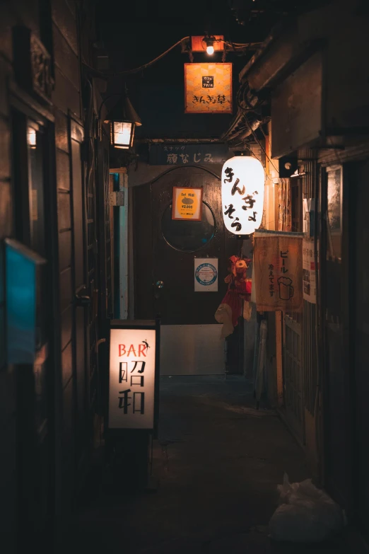 a narrow alley in an asian village has a sign pointing to do some kind of soing