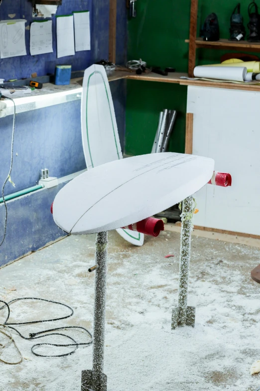 surf board being constructed in a garage next to wires