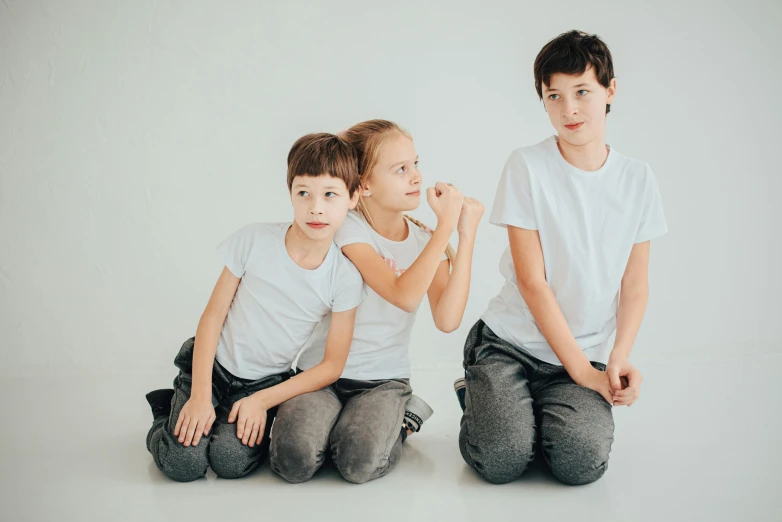 a couple of boys sitting on top of a white floor